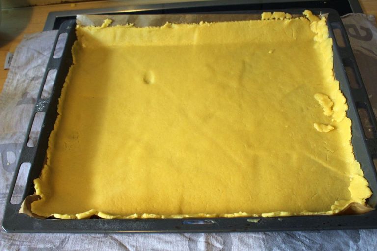 Ich rolle den Teig immer auf einem Backpapierblatt aus und lege es danach aufs Blech.