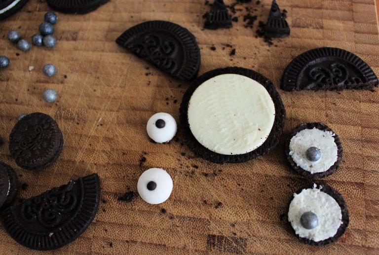 Dekoration: Dreht einen Oreokeks auseinander. Die Seite "A", an der keine Creme ist, halbiert ihr. Das werden die Flügel.