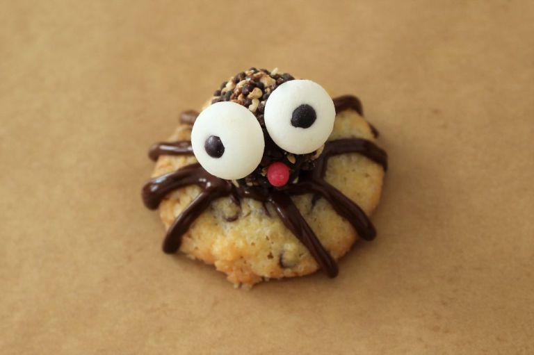 Wer es auf die Spitze treiben will, klebt vorne noch eine rote Zuckerperle auf, und die Spinne streckt uns die Zunge raus.