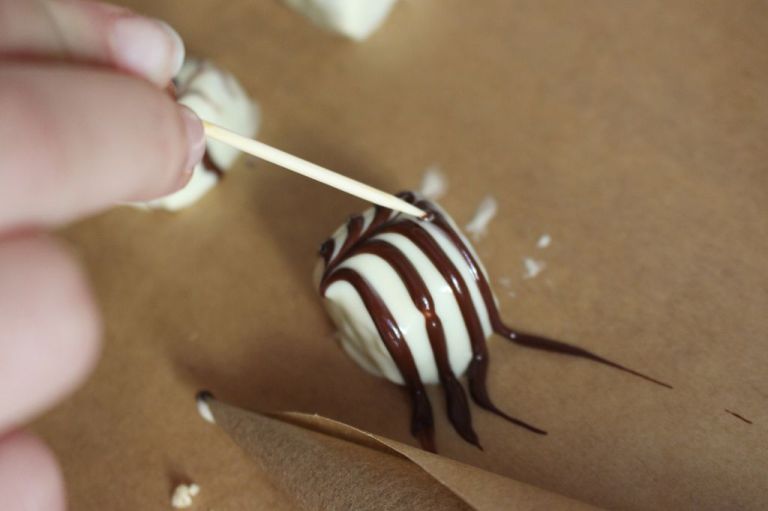 Für die Netz-Optik mit einem Zahnstocher die Streifen durchbrechen. Achtung: Helle und dunkle Schokolade müssen hier noch feucht sein.